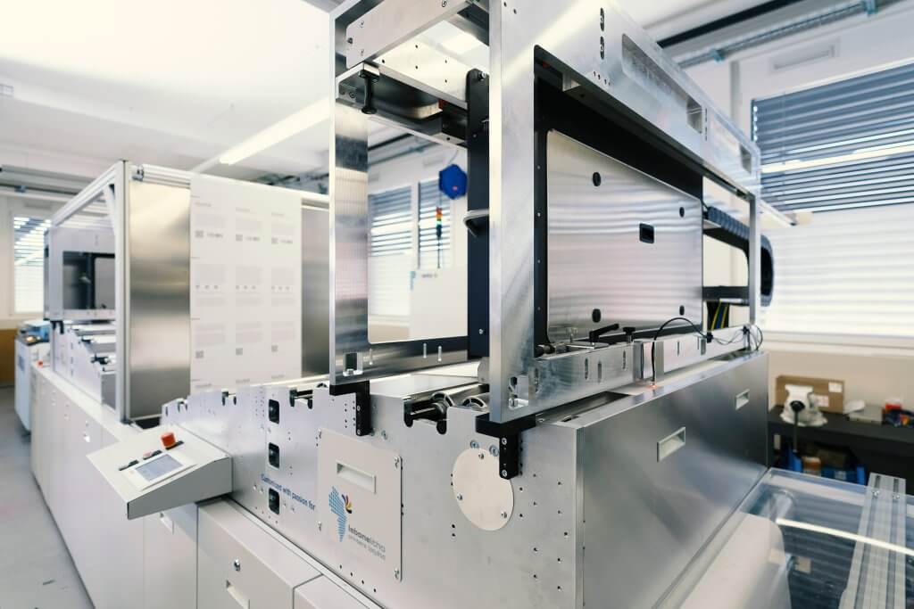 Worker installing printheads in large printbar